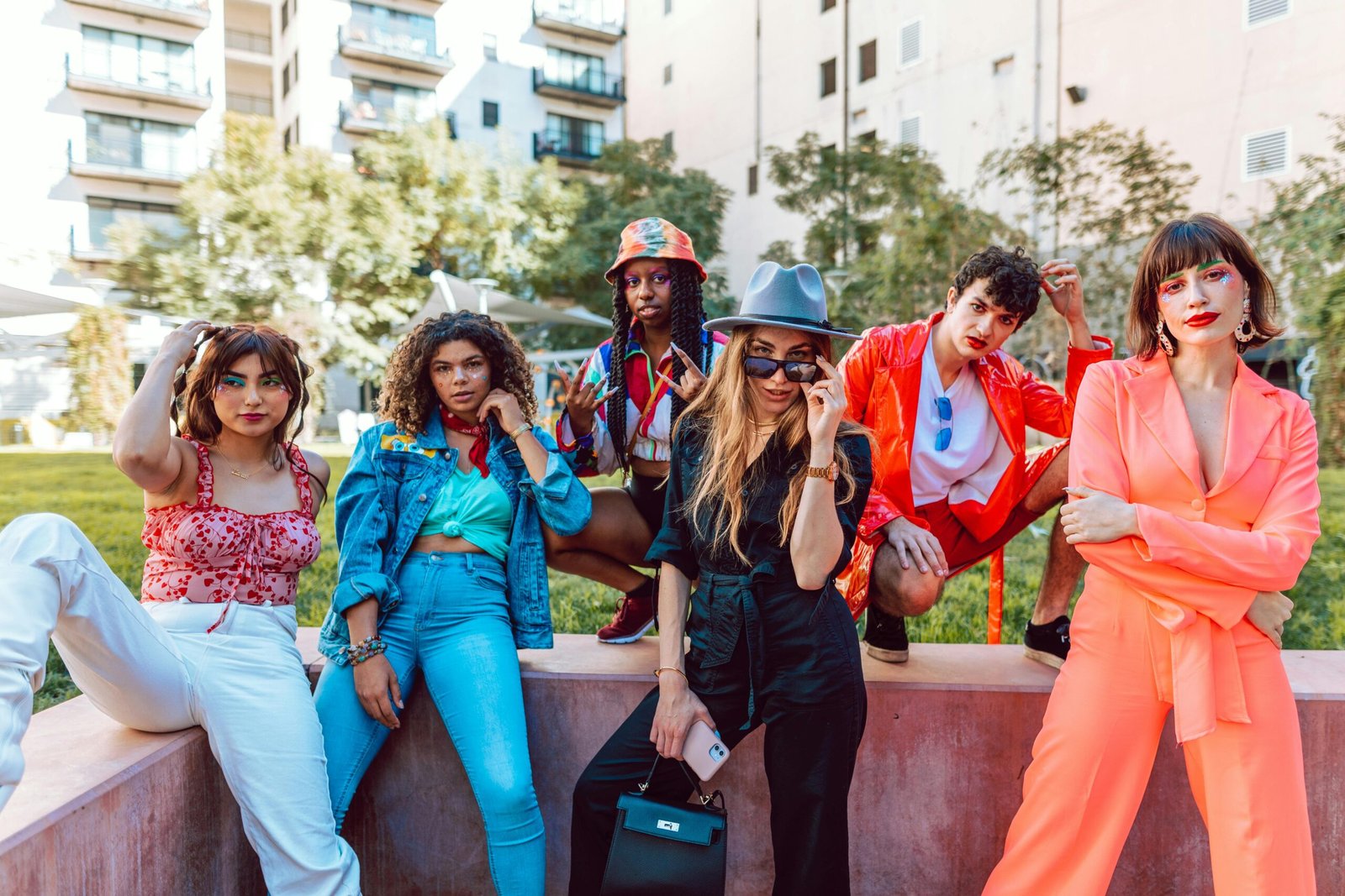 A diverse group of stylish young adults posing together in an urban outdoor setting.