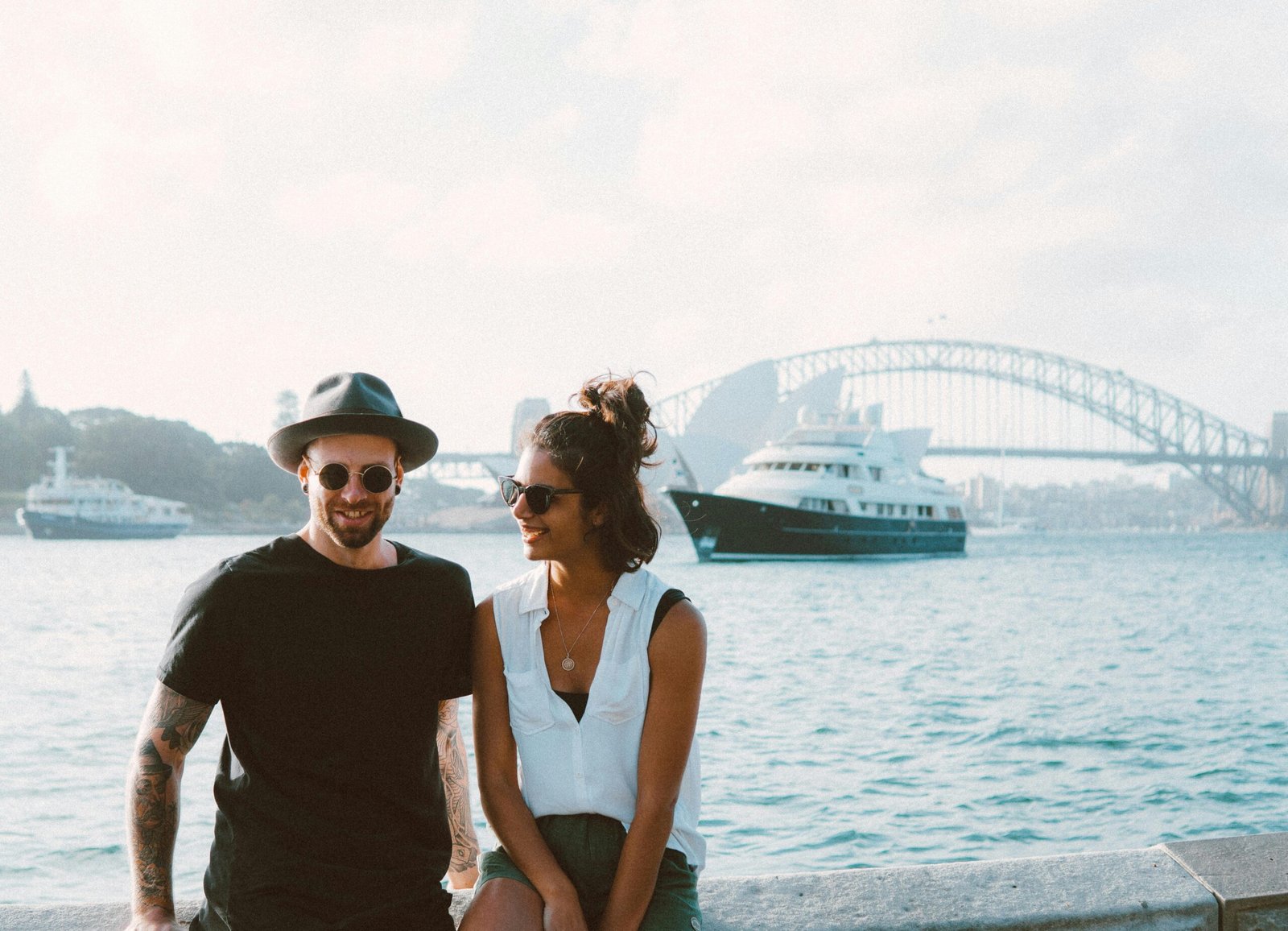 A happy couple enjoying a sunny day by Sydney Harbour with the iconic bridge in the background.